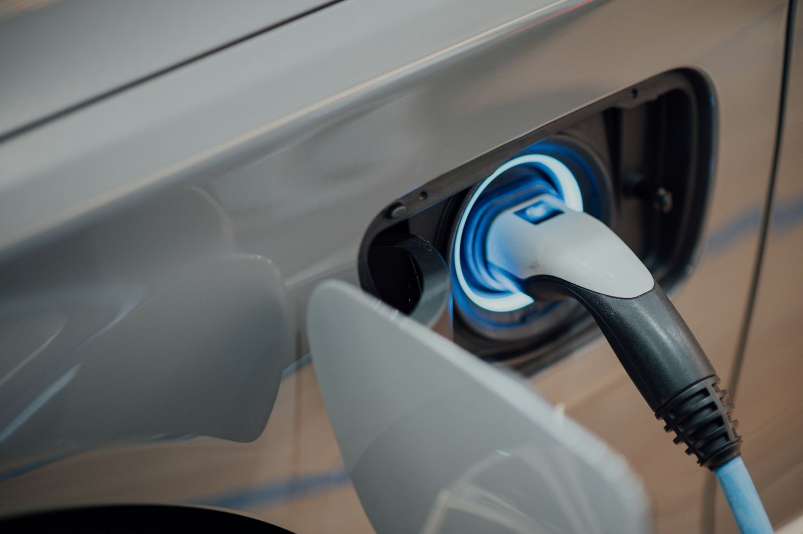 Câble de recharge branché sur la prise d'une voiture électrique grise