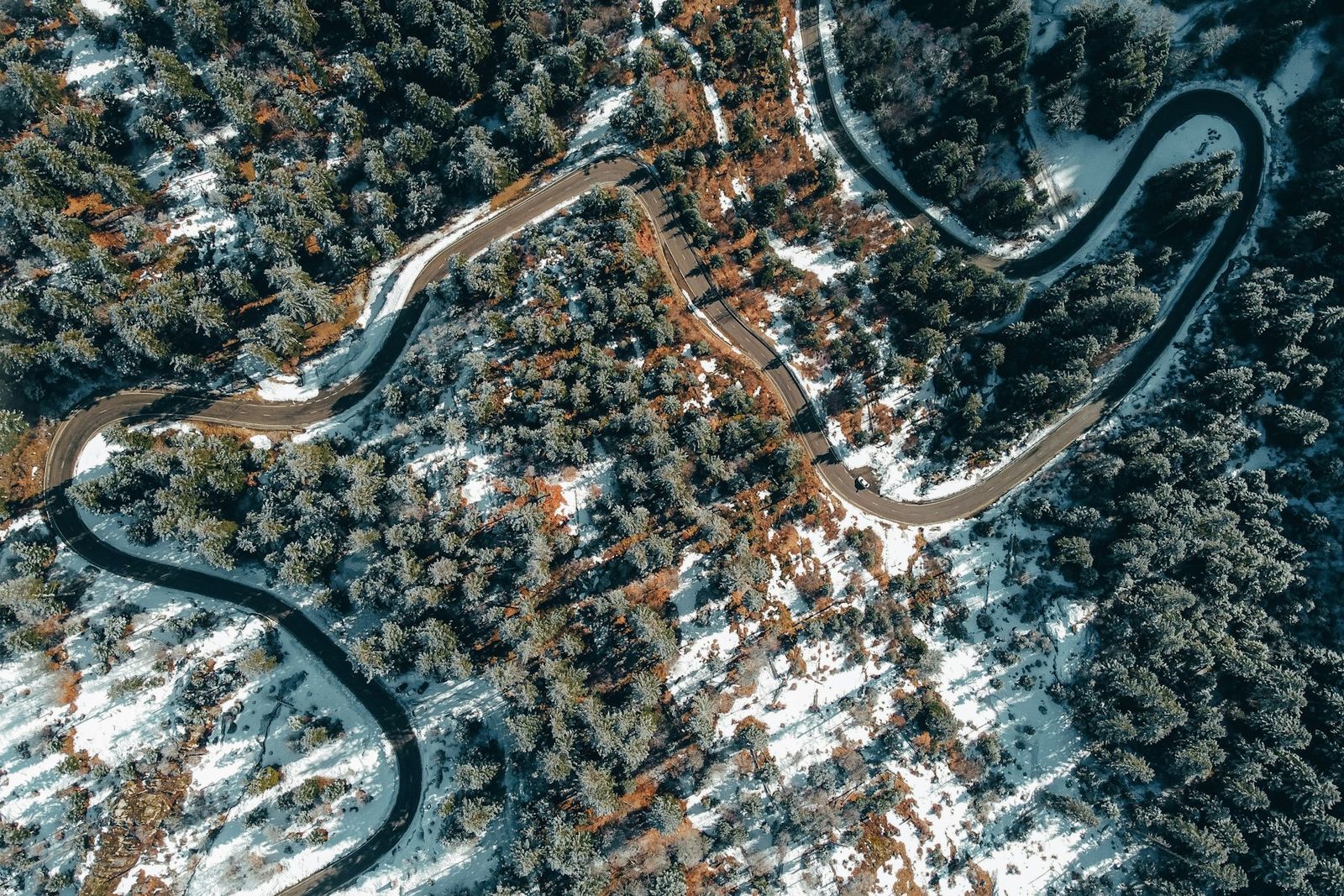 Route de montagne sinueuse sous la neige, vue du ciel