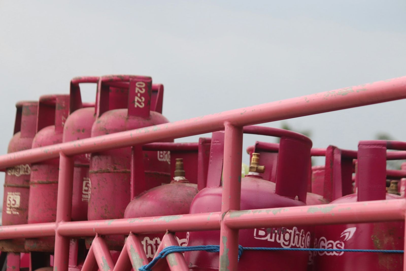 Bouteilles de gaz rouges alignées derrière une rambarde