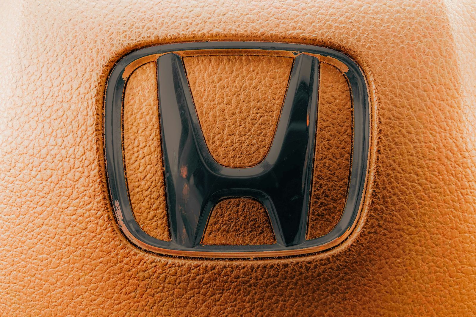 Logo Honda en relief sur un cuir orange