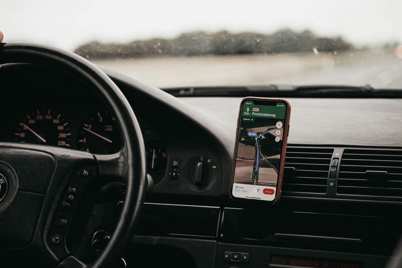 Smartphone avec un itinéraire fixé sur le tableau de bord