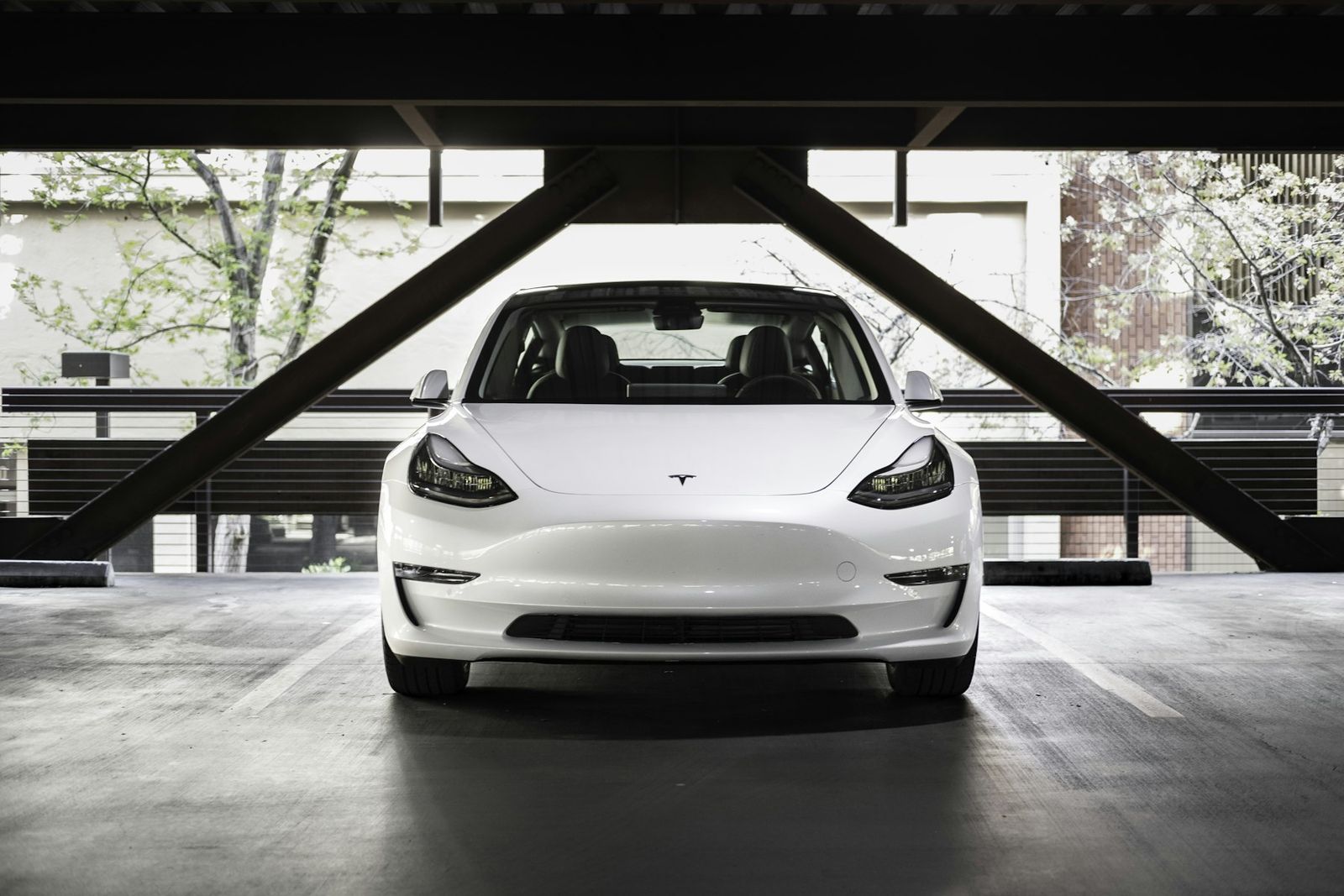 Tesla Model 3 blanche de face dans un parking couvert