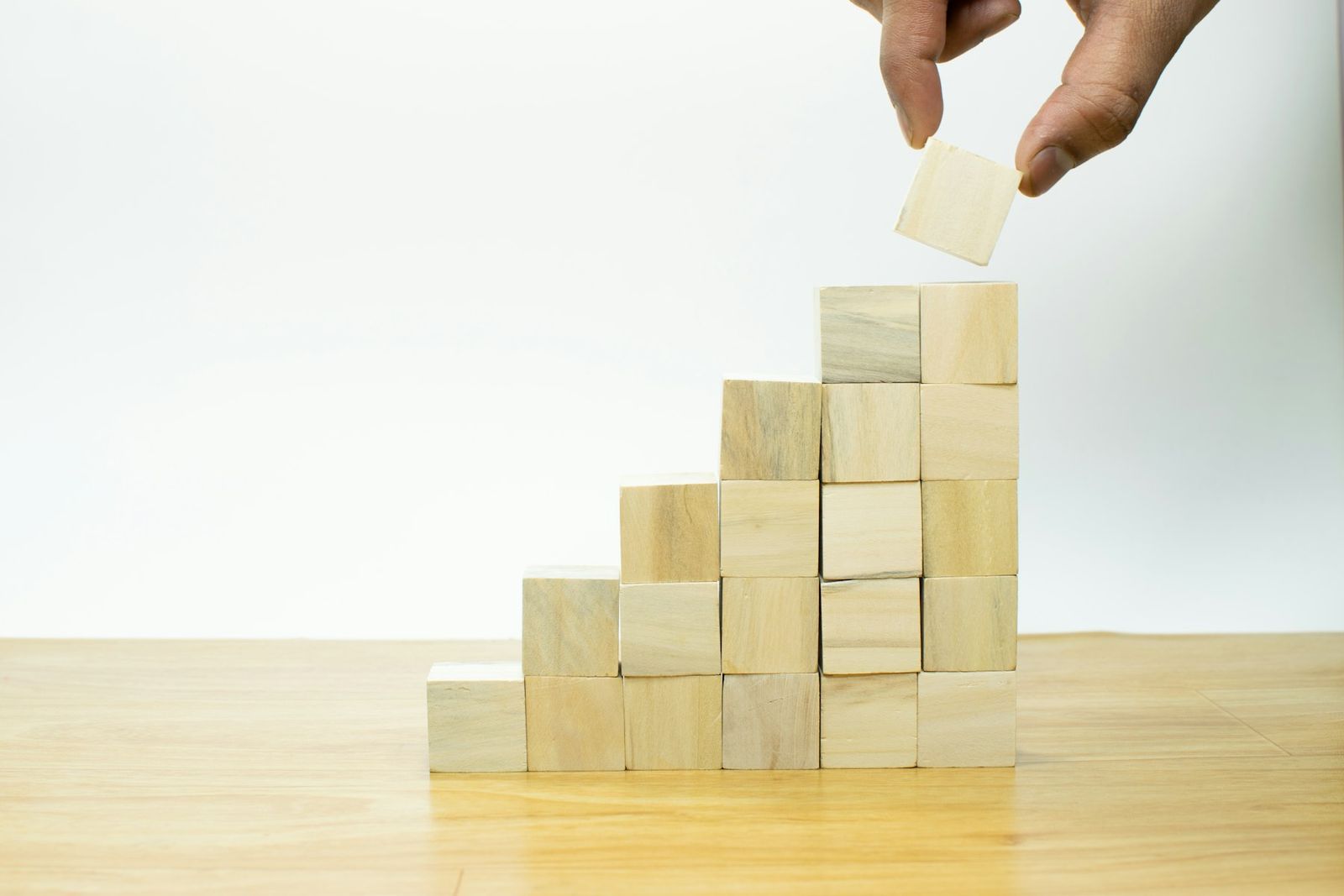 Main empilant des cubes de bois en escalier